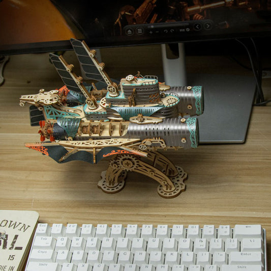Wooden steampunk-style model ship on a desk with a lizard figurine.