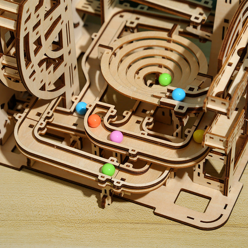 Wooden mechanical model with colorful balls on a wooden surface