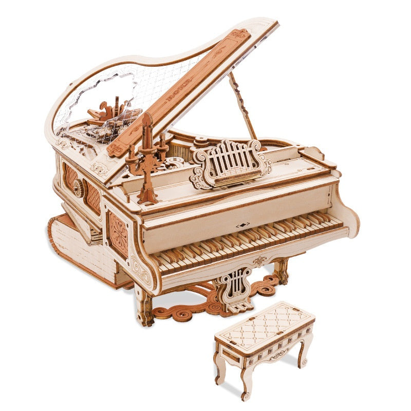 Wooden model of a grand piano with open lid on a white background