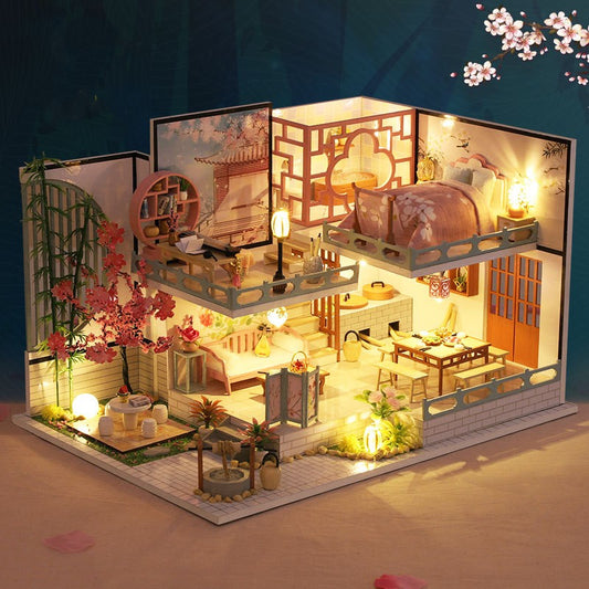 Detailed model of a miniature house with interior lighting, furniture, and decorative elements.