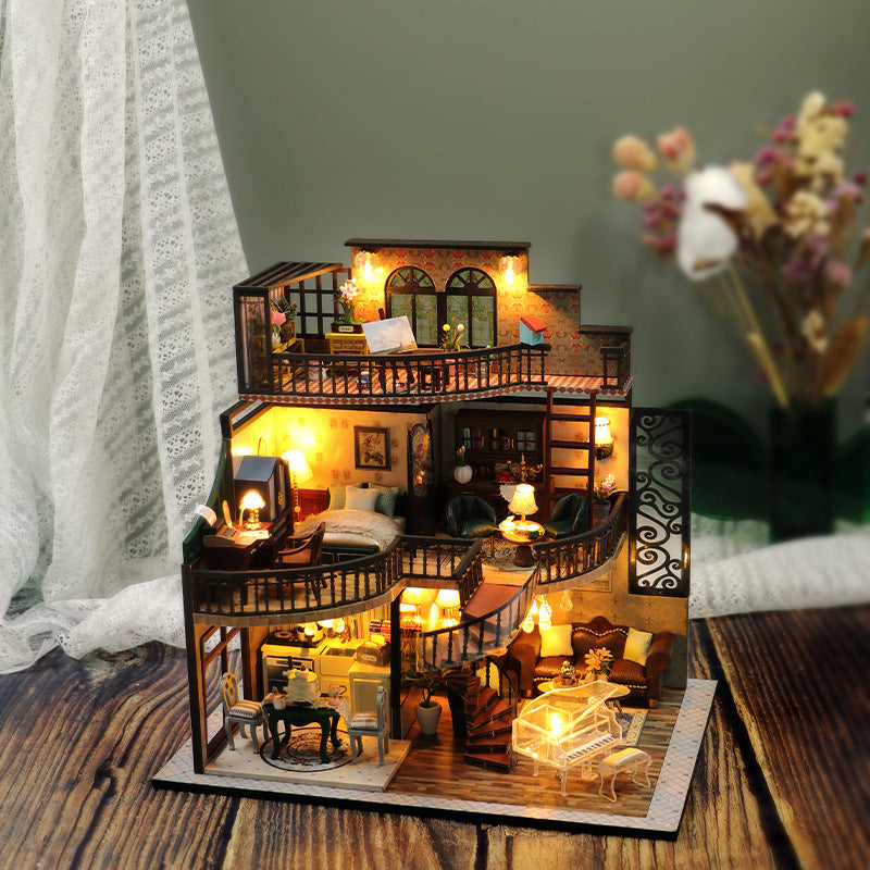Detailed model of a house with interior furniture on a wooden surface.