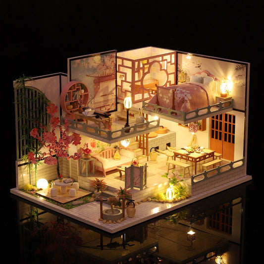 Detailed model of a miniature house with interior lighting, furniture, and decorative elements.