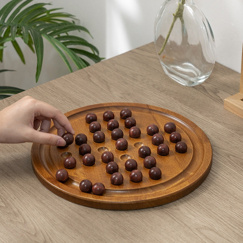 Wooden board game with marbles on a wooden table