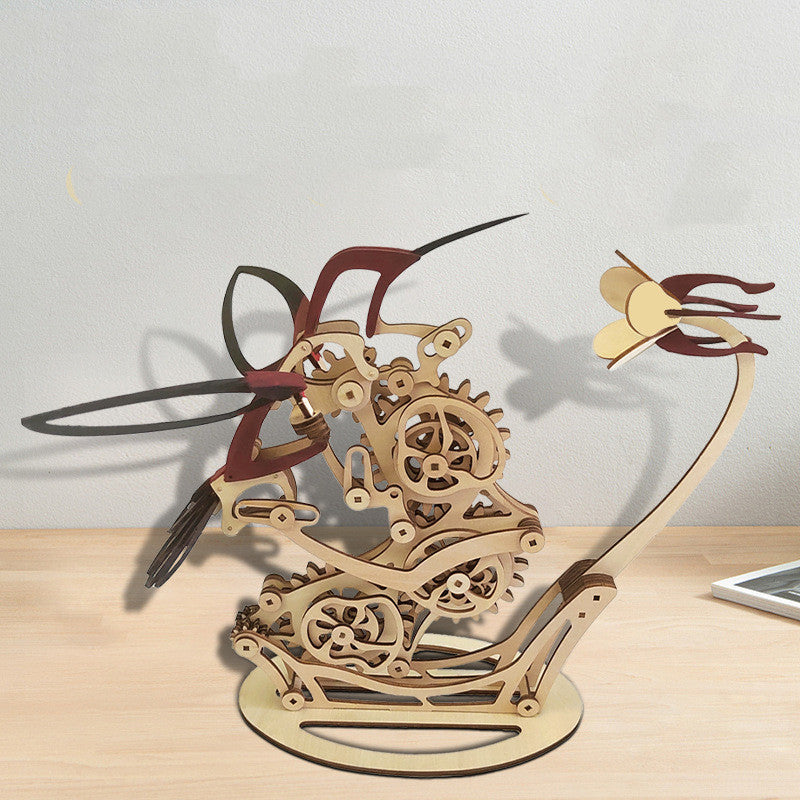 Wooden mechanical model of a hummingbird on a light surface.
