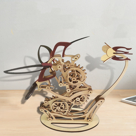 Wooden mechanical model of a hummingbird on a light surface.