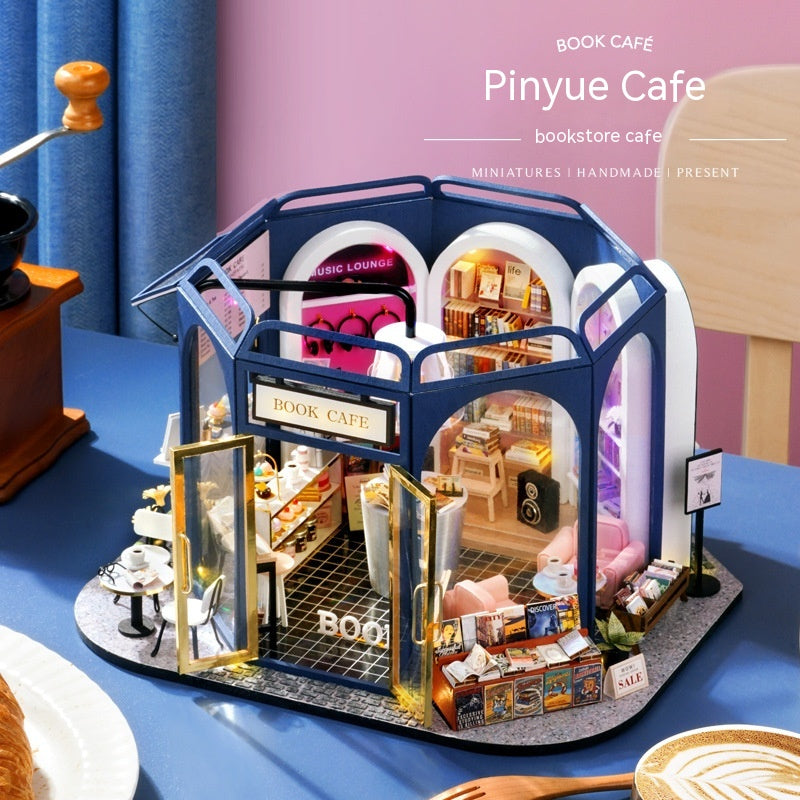 Model of a book-themed cafe with detailed interior on a blue surface