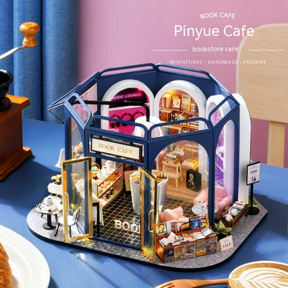 Model of a book-themed cafe with detailed interior on a blue surface