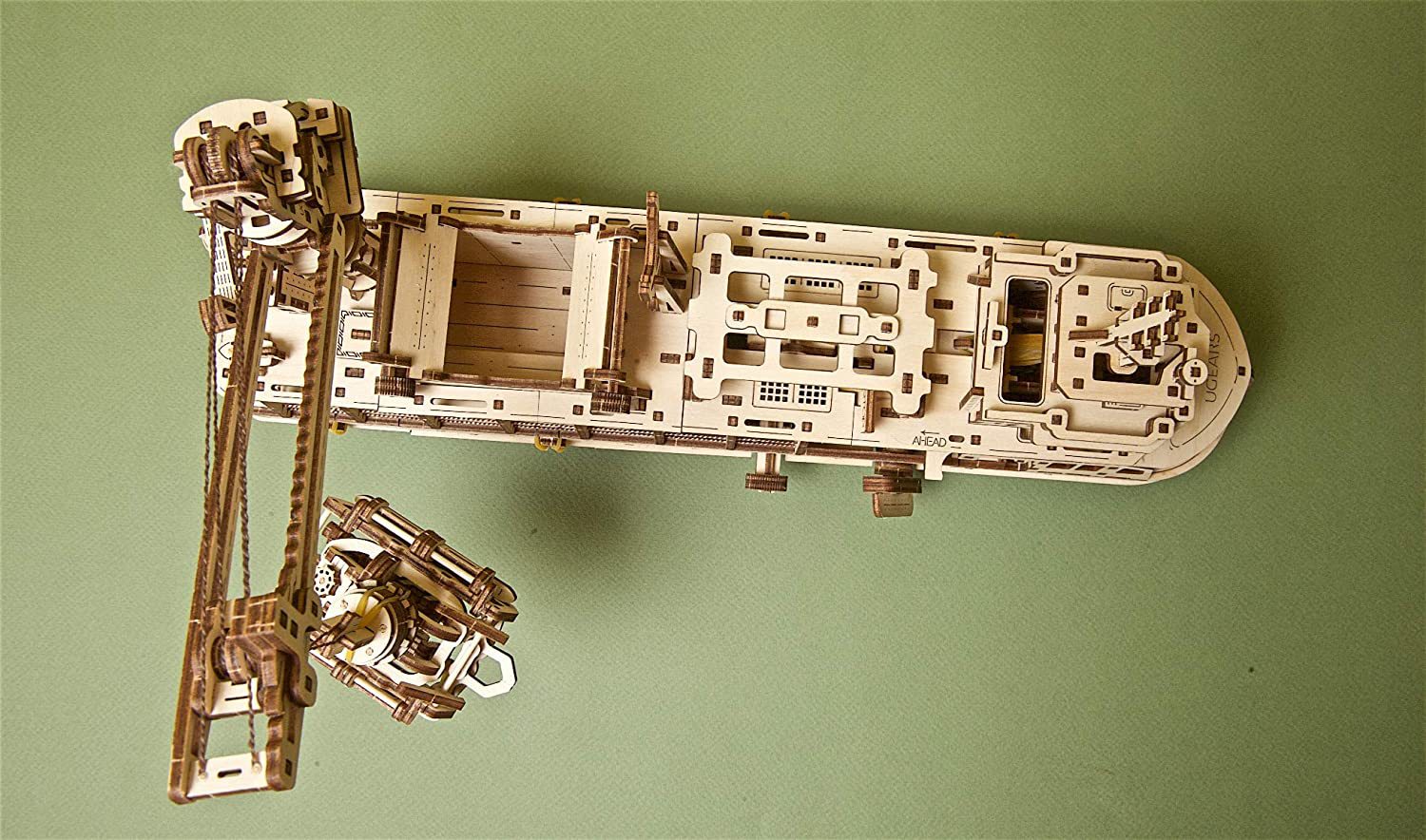 Wooden mechanical model of a ship on a green background